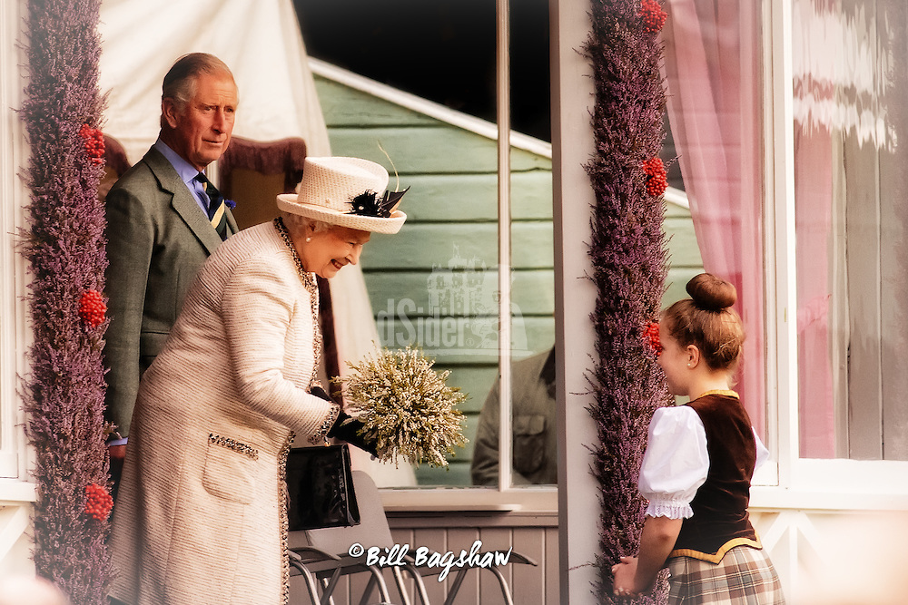 Her Majesty The Queen accepts flowers whilst prince Charles looks on Braemar Gathering 2014 (Bill Bagshaw/M.Williams/COPYRIGHT)